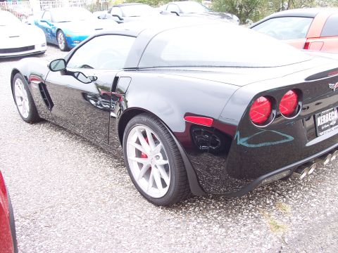 2006 Chevrolet Corvette - Rear quarter view of a black Chevrolet Corvette, showing its distinctive taillights and quad exhaust pipes. The vehicle appears to be a 200…