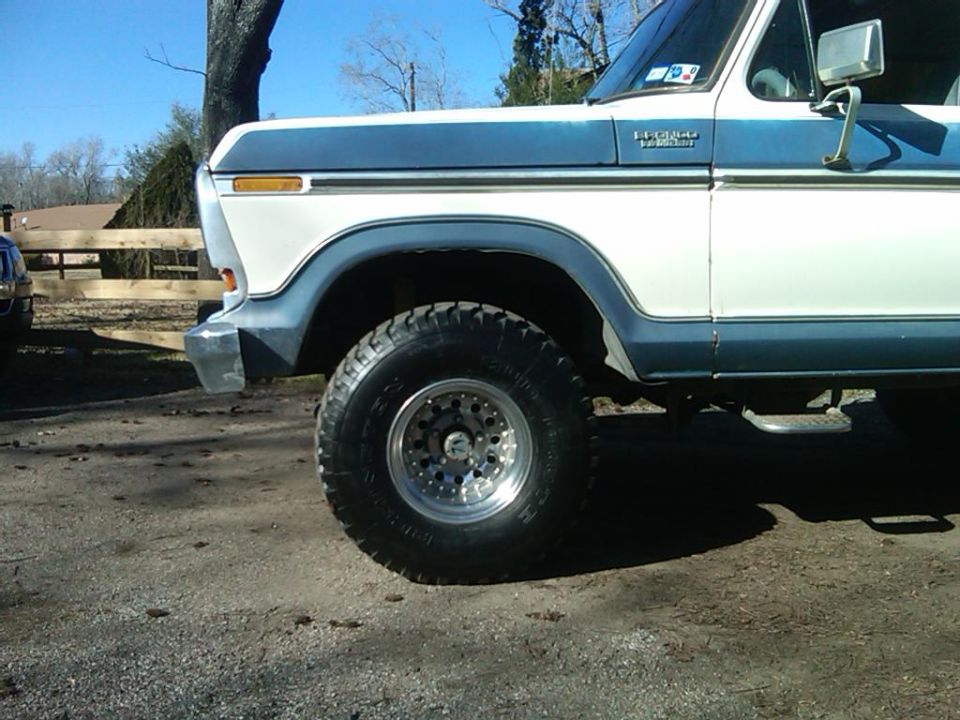 Front fender and wheel of a blue and white 1978 Ford Bronco