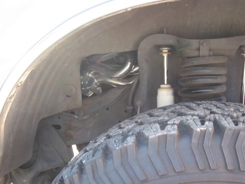1994 Ford Bronco - Chrome Bassani headers are visible within the wheel well of a vehicle.