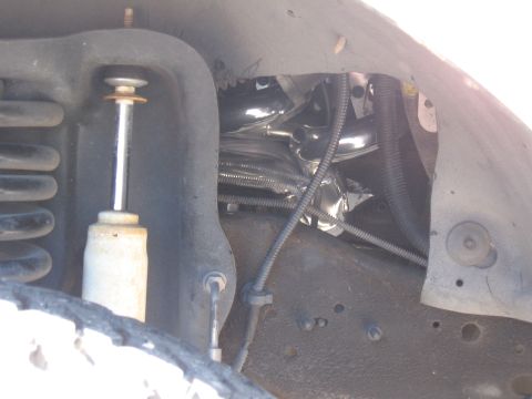 1994 Ford Bronco - Engine exhaust headers installed on a vehicle, showing heat shielding and suspension components.