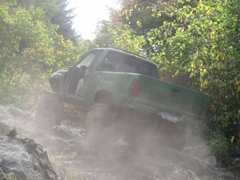 1979 Ford Bronco - This modified pickup truck navigates a challenging off-road course, kicking up dust.
