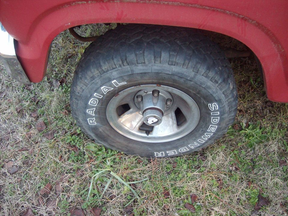 Close-up of a red vehicle's wheel and Sidewinder radial tire