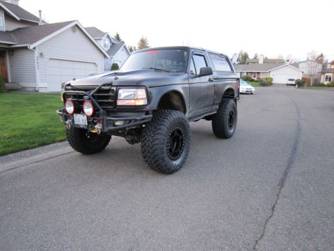1996 Ford Bronco - This lifted 1996 Ford Bronco features an aftermarket bumper with auxiliary lights and large off-road tires.
