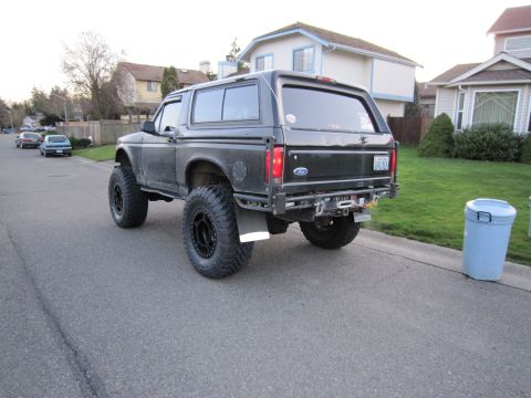 1996 Ford Bronco - Rear view of a modified 1996 Ford Bronco showing its lifted suspension and large tires.