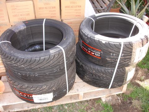 1995 Ford Taurus - Several new tires are stacked on wooden pallets, ready for transport or sale.