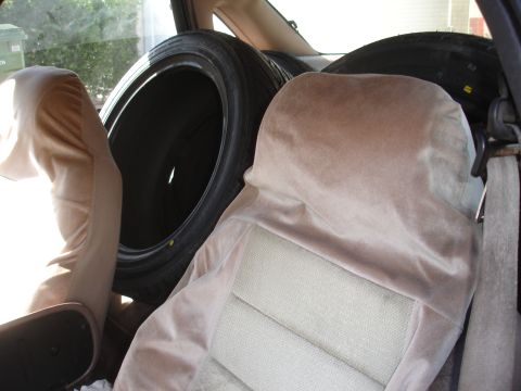 1995 Ford Taurus - Interior view of a car's back seat area, with two tires loaded behind the front seats.