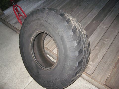 1986 Ford Bronco - BFGoodrich All-Terrain T/A tire shown with a red jack in the background.
