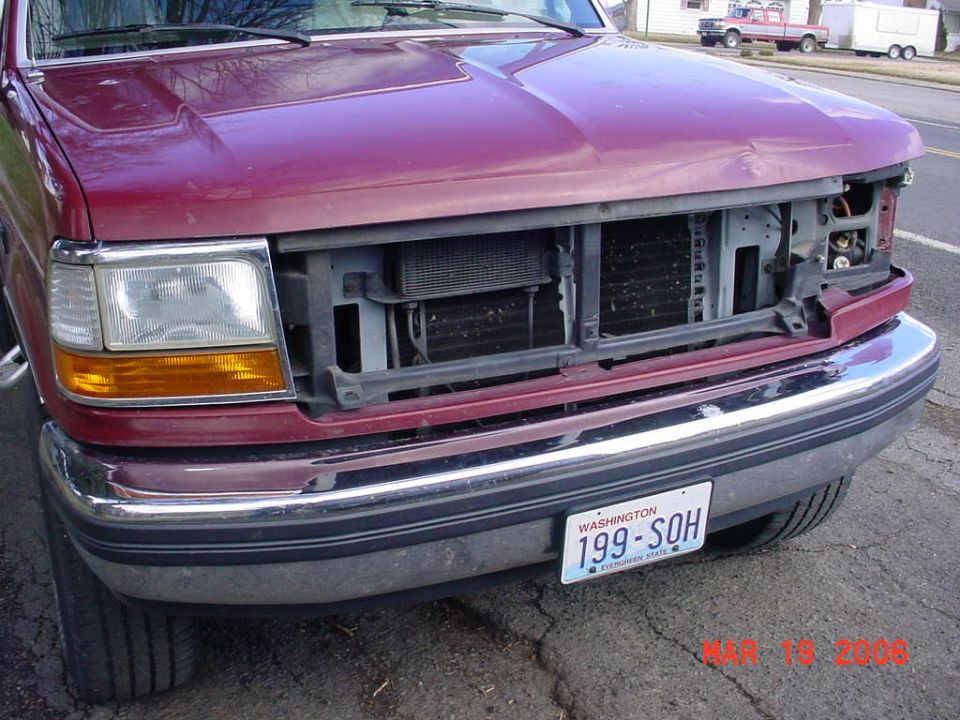 1992 Ford Bronco front end with missing grille and damaged hood