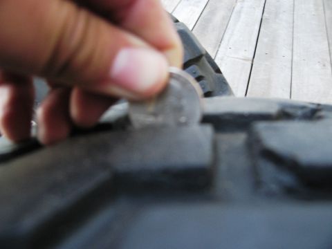 1986 Ford Bronco - Measuring tire tread depth with a quarter.
