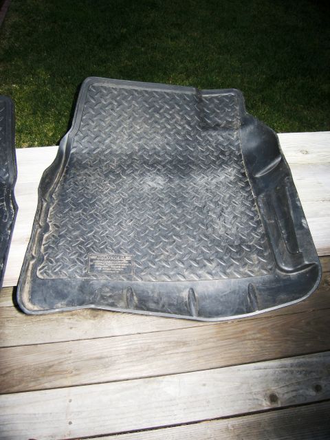 1986 Ford Bronco - A single rubber floor mat with a textured surface is shown on a wooden deck.