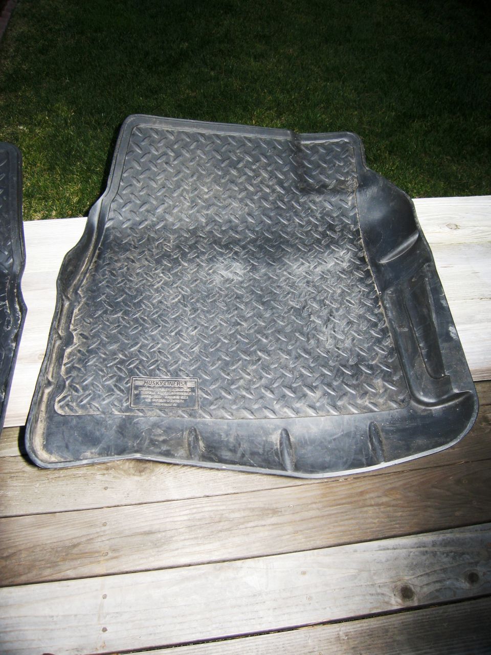 Black rubber floor mat with diamond tread pattern and raised edges