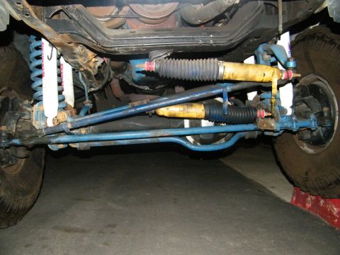 1982 Ford Bronco - Close-up of the front suspension and steering system of a vehicle, showing various mechanical parts.