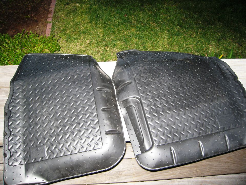 Two black diamond-tread rubber floor mats with raised edges, viewed from above
