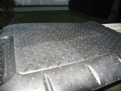 1986 Ford Bronco - Close-up of a spiked diamond plate floor mat, likely a vehicle accessory.