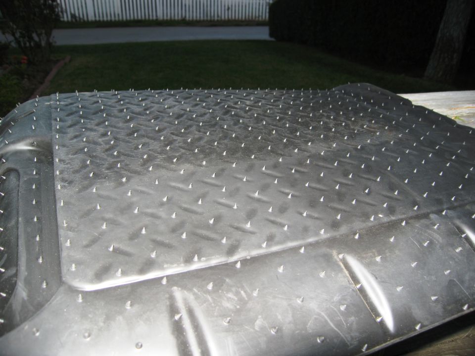 Diamond plate floor mat with raised spikes, possibly for a vehicle