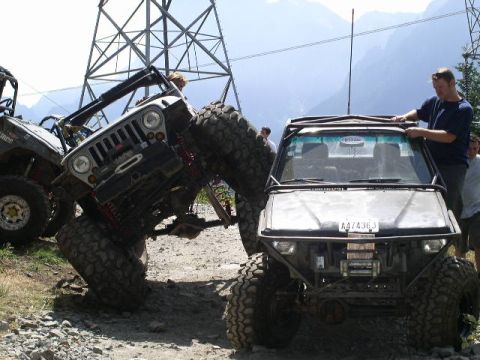 1979 Ford Bronco - Modified off-road vehicles navigate a challenging terrain with power lines overhead.