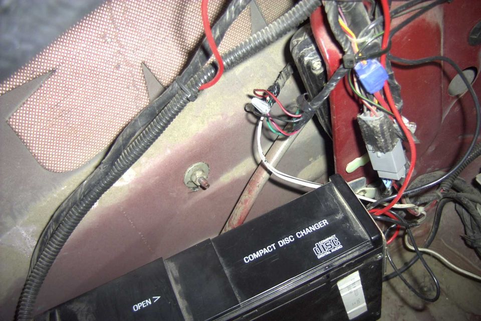 Car interior showing wiring harness and a compact disc changer unit