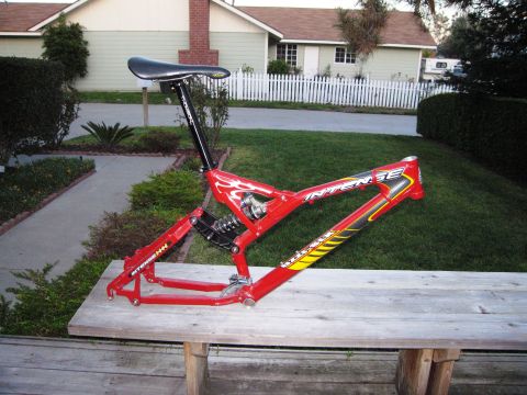 1986 Ford Bronco - A red bicycle frame with "INTENSE" branding sits on a wooden table outdoors.