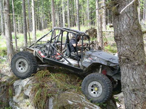 1979 Ford Bronco - Custom off-road buggy navigating rocky terrain in a wooded area.