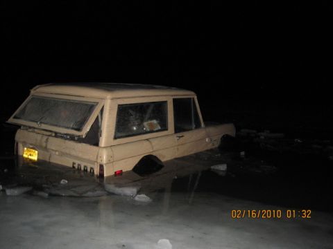 1990 Ford F-250 - Tan SUV seen from the rear at night. The vehicle appears to be stationary.