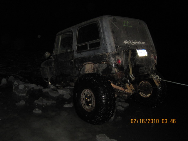 Gray van with front end damage, parked at night