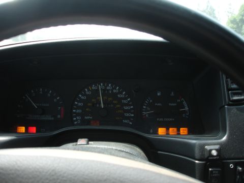 1993 Ford Taurus - The dashboard shows the vehicle is in motion, with multiple warning lights illuminated on the instrument panel.