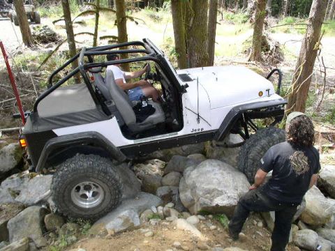 1979 Ford Bronco - Jeep Wrangler tackling a rocky trail with another vehicle in the background.