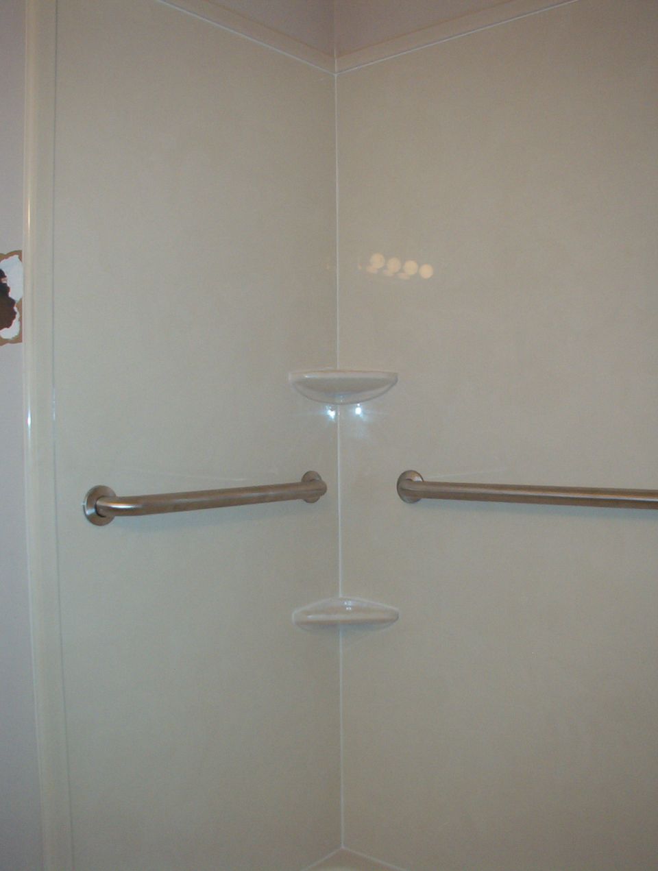 Shower stall interior with grab bars and soap dish. Watermark reads SUPERMOTORS