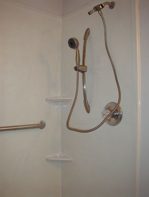 2004 Land Rover Land Rover - A shower stall interior with a grab bar, soap dishes, and a shower head assembly.