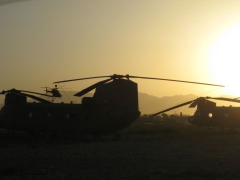 2003 Jeep TJ - Multiple helicopters are parked on the ground during a hazy sunset with mountains visible in the distance.