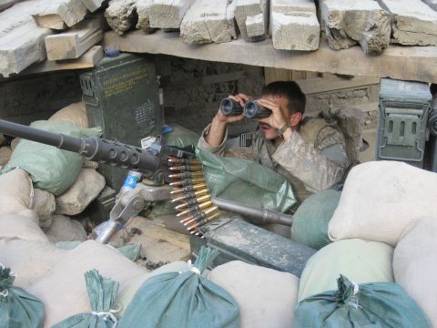 2003 Jeep TJ - A soldier observes his surroundings through binoculars, positioned with a heavy machine gun and ammunition.