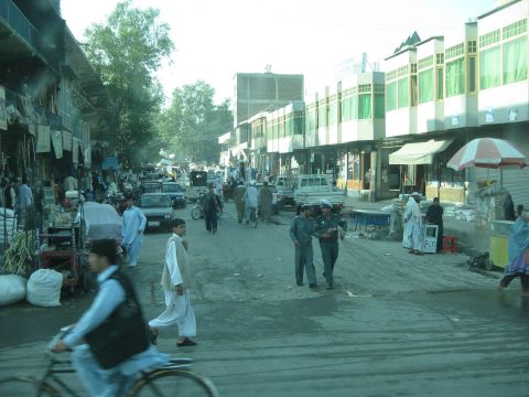 2003 Jeep Wrangler - A busy street market scene with pedestrians and various vehicles.
