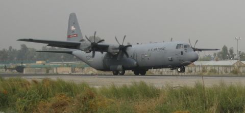 2003 Jeep Wrangler - A C-130 Hercules aircraft is on the runway, with a helicopter visible in the distance.