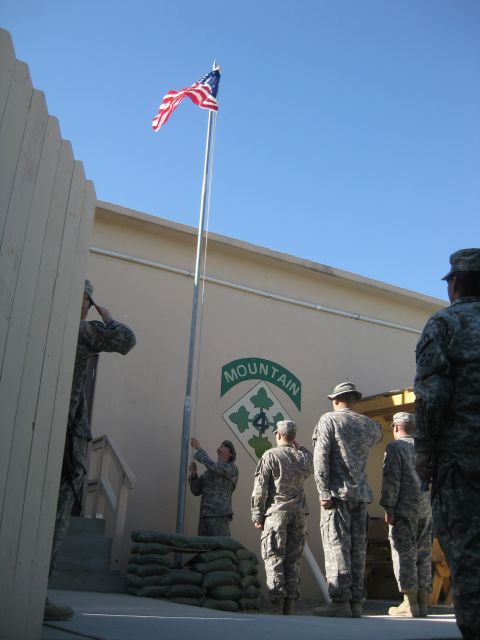 2003 Jeep Wrangler - Soldiers participate in a flag-raising ceremony outside a building marked with a military unit emblem.