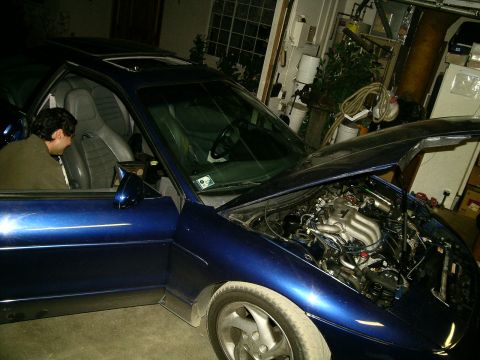 1995 Ford Probe - A blue coupe is parked in a garage with its hood and driver's door open.