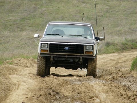 1982 Ford Bronco - Ford Bronco navigates a muddy off-road trail.