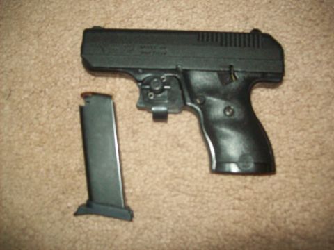 1985 Ford Bronco - A black handgun and its detached magazine are shown on a carpeted surface. The Supermotors.net logo is visible in the lower right corner.