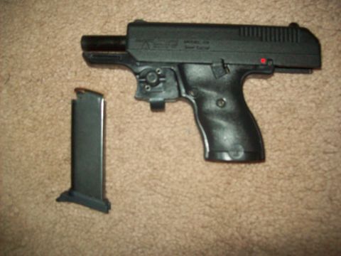1985 Ford Bronco - A pistol and its detached magazine are shown on a carpeted surface.