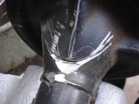 1995 Ford Taurus - Damaged suspension part shows significant wear and tear, with white paint markings indicating repair or identification.