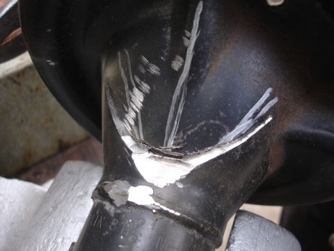 1995 Ford Taurus - Close-up of a damaged black metal suspension component with white paint markings.