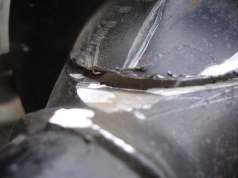1995 Ford Taurus - A close-up view reveals damage to a metal suspension part, showing signs of wear and tear.