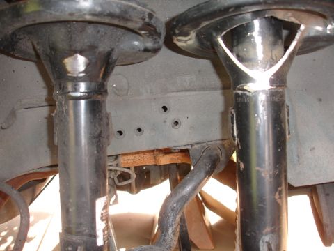 1995 Ford Taurus - Close-up view of front strut mounts and sway bar, likely from a vehicle's suspension system.