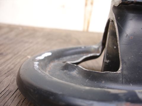 1995 Ford Taurus - This is a close-up view of a black metal automotive part, likely a suspension component, showing wear and tear.