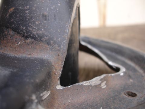 1995 Ford Taurus - Close-up of a worn and rusty automotive suspension part, showing signs of metal fatigue and repair marks.