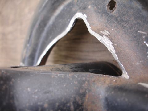 1995 Ford Taurus - Modified metal bracket with a triangular cut-out, showing signs of recent cutting.