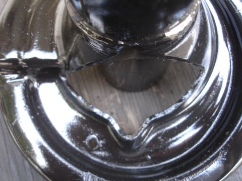 1995 Ford Taurus - Close-up of a damaged chrome wheel cover, showing a V-shaped opening and reflective surface.