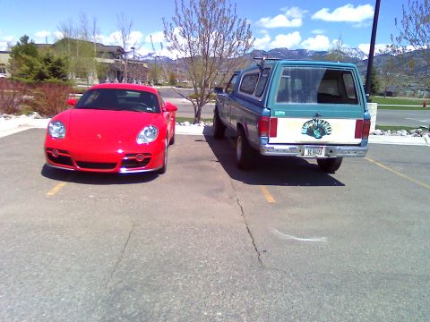 2006 Ford E350 - Two vehicles, a red sports car and a blue pickup truck, are parked in an outdoor lot.