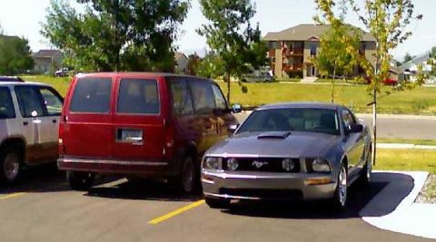 2006 Ford E350 - A silver Ford Mustang is parked in a lot, with other vehicles nearby.