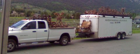 2006 Ford E350 - Pickup truck hauls a trailer filled with antlers and furniture, with text for Antler Lighting & Furniture visible on the trailer.