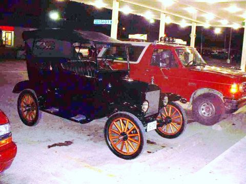 2006 Ford E350 - Two vehicles, an antique car and a red pickup, are parked side-by-side at night.